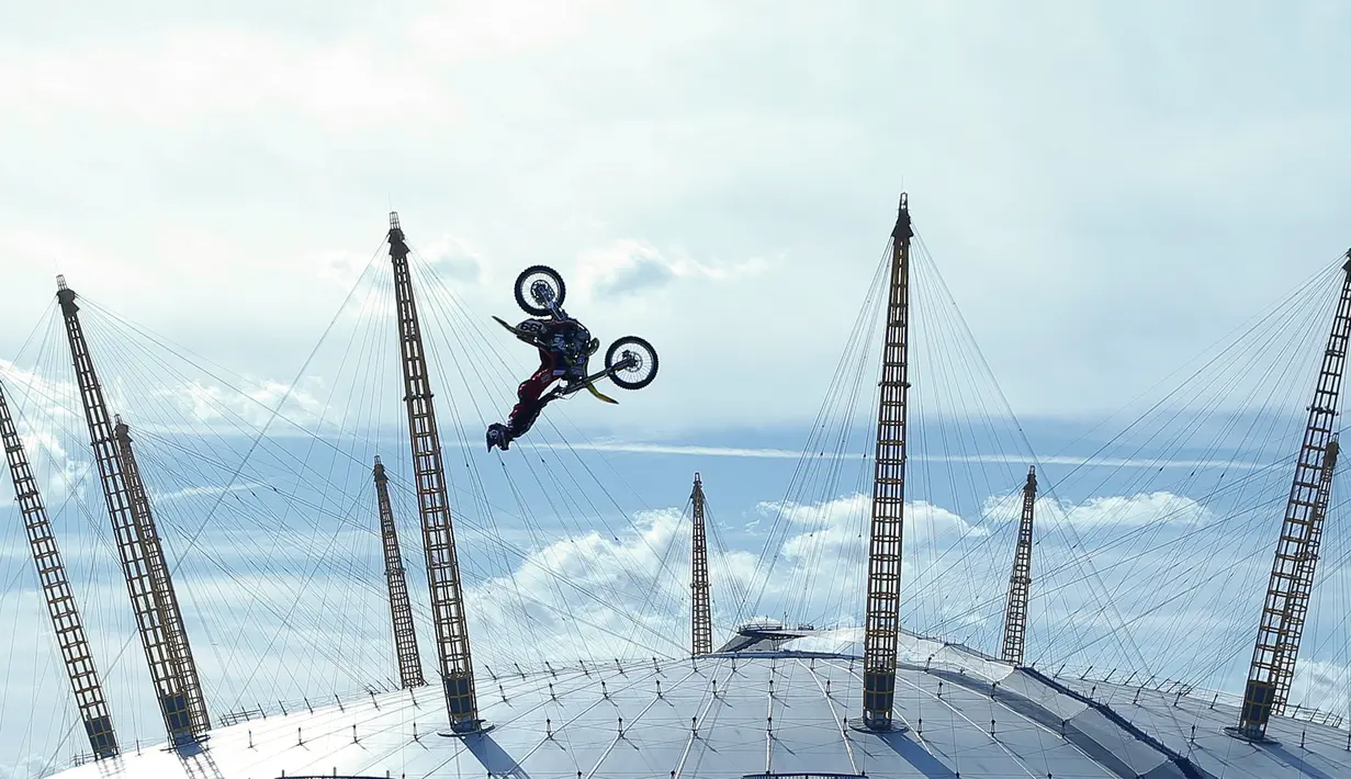 Atraksi Travis Pastrana saat backflip dengan sepeda motornya di atas Sungai Thames, London, Kamis (5/10). Selama Pastrana berkarier, 90 tulangnya pernah patah dan 25 kali alami gegar otak. (AP Photo/Alastair Grant)