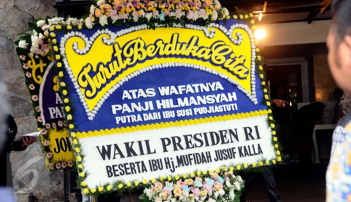 Petugas menaruh karangan bunga duka cita dari Wapres Jusuf Kalla di kediaman Menteri Kelautan dan Perikanan Susi Pudjiastuti, Jakarta, Senin (18/1/2016). Putra Menteri Susi, Panji Hilmansyah wafat di Florida, AS. (Liputan6.com/Helmi Fithriansyah)