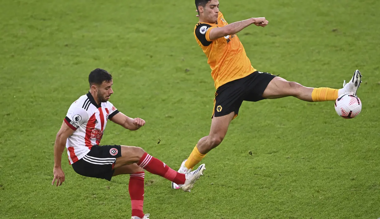 Penyerang Wolverhampton Wanderers, Raul Jimenez  berusaha merebut bola tendangan pemain Sheffield United, George Baldock pada pertandingan Liga Inggris di stadion Bramall Lane, Inggris, Senin, (14/9/2020). Wolves menang 2-0 atas Sheffield United. (Laurence Griffiths/Pool via AP)