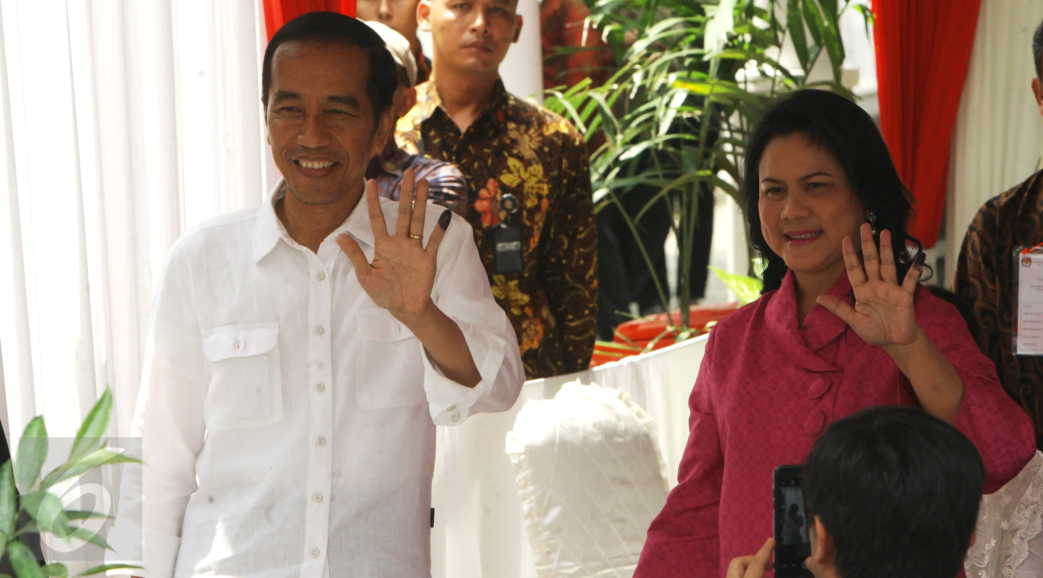 Presiden Joko Widodo (Jokowi) didampingi Ibu Negara, Iriana, memperlihatkan jarinya yang telah dicelup tinta setelah menyalurkan hak pilih mereka pada Pilkada DKI 2017 putaran kedua di TPS 04 Gambir, Jakarta, Rabu (19/4). (Liputan6.com/Angga Yuniar)