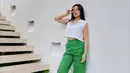 Sleeveless top warna putih dan high waisted pants warna hijau, nyaman untuk hangout. [Instagram/aaliyah.massaid]