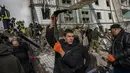 Petugas memindahkan puing-puing setelah serangan Rusia di sebuah bangunan tempat tinggal di Uman, Ukraina tengah, Jumat, 28 April 2023. (AP Photo/Bernat Armangue)
