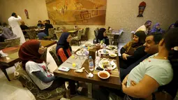 Pemerintah Irak mencabut pemberlakuan jam malam mulai Minggu 8 Februari 2015, Irak, Kamis (9/7/2015). Sejumlah warga merayakan pencabutan jam malam tersebut dengan mengadakan sahur bersama di sebuah Kafe. (Reuters/Thaier Al-Sudani)