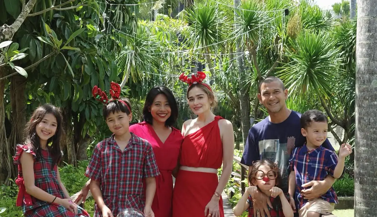 Rayakan Natal bersama keluarga, Yasmine Wildblood tampil kasual dalam balutan one shoulder dress merah. Dress ini dilengkapi dengan belt cokelat dan bando tanduk rusa [@yaswildblood]