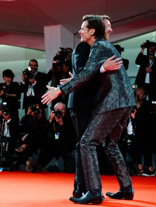 Jim Carrey memeluk Sutradara Chris Smith saat menghadiri pemutaran film 'Jim and Andy: The Great Beyond' selama Festival Film Venice ke-74 di Venesia, Italia, (5/9). (AFP Photo/Domenico Stinellis)