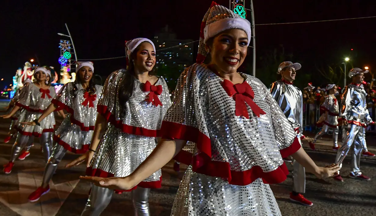 Seorang pria dan wanita bernari merayakan parade  Natal Panama City (16/12). Warga Panama tengah mempersiapkan diri menyambut datangnya Natal 2018 yang jatuh pada tanggal 25 Desember. (AFP Photo/Luis Acosta)