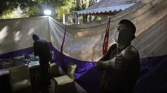 Reaksi seseorang ketika menunggu setelah menerima vaksin COVID-19 di sebuah pasar di New Delhi, Rabu (29/12/2021). Di India, yang telah kembali normal setelah dihantam tsunami COVID-19 tahun ini, omicron sekali lagi menimbulkan ketakutan, dengan lebih dari 700 kasus dilaporkan. (AP Photo/Manish Sw