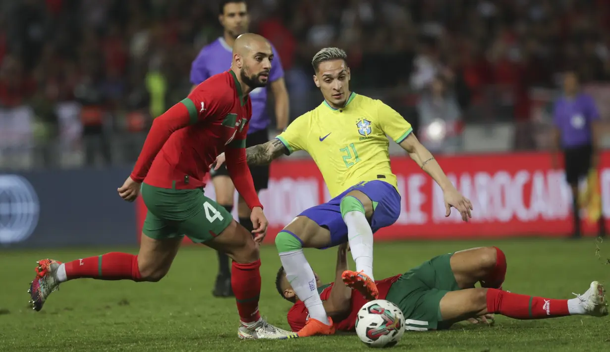Pemain Brasil, Antony, berusaha melewati pemain Maroko, Sofyan Amrabat, pada laga uji coba FIFA Matchday di Grand Stade de Tanger, Tangier, Minggu (26/3/2023). (AP Photo/Mosa'ab Elshamy)
