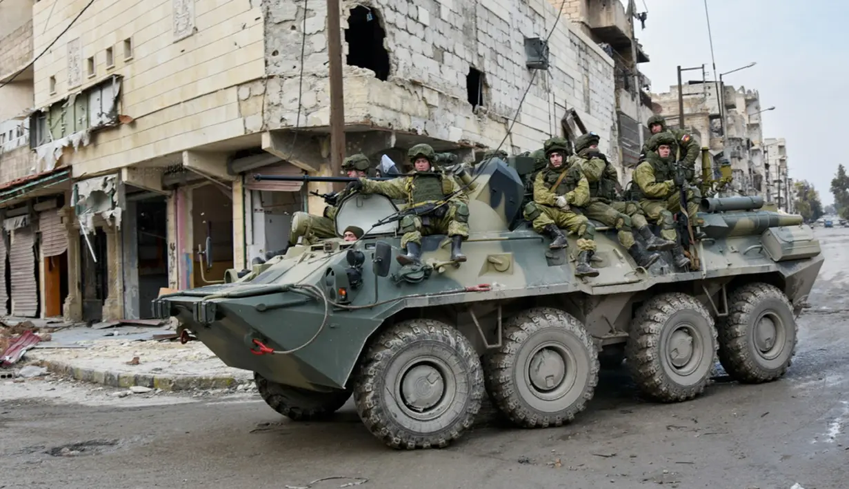 Tentara Rusia berada di kendaraan militer saat melakukan patroli dalam operasi APCs di Aleppo, Suriah. (Russian Defense Ministry Press Service photo via AP)