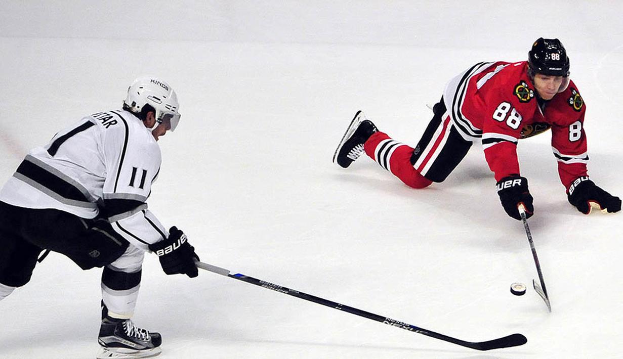 Aksi atlet hoki Los Angeles Kings, Anze Kopitar berebut bola dengan pemain Chicago Blackhawks, Patrick Kane di Chicago, Amerika Serikat, Selasa (15/3/2016). (Reuters/David Banks) 