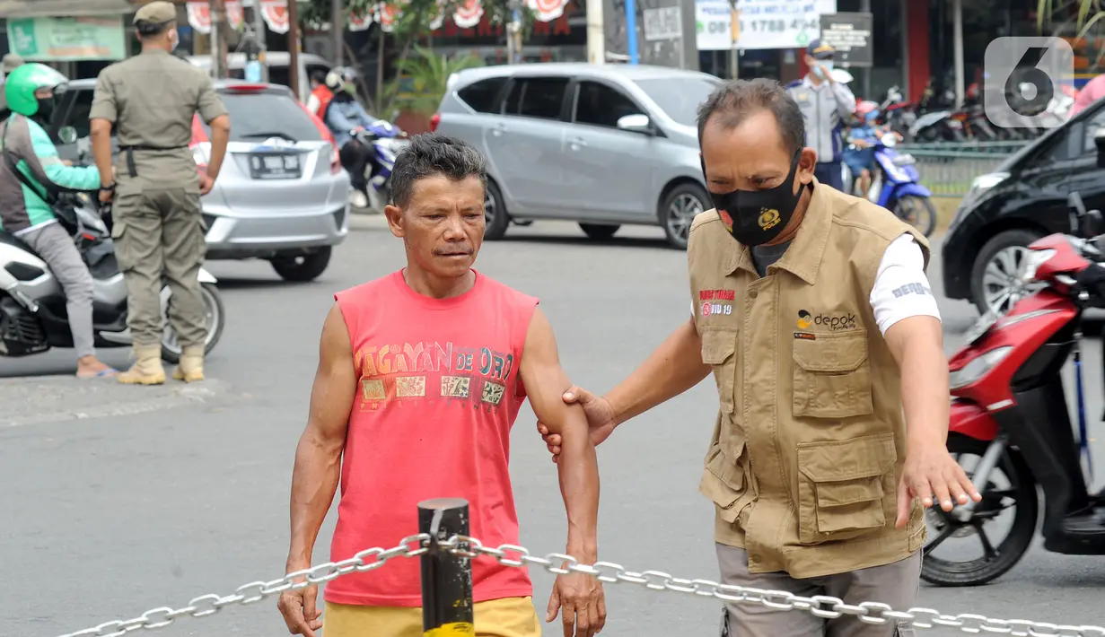Petugas membawa warga yang tidak mengenakan masker saat razia pelanggar PSBB di Jalan Raya Cinere, Depok, Jawa Barat, Senin (24/8/2020). Razia ditujukan bagi warga yang tidak mengenakan masker untuk menekan penyebaran COVID-19. (merdeka.com/Arie Basuki)
