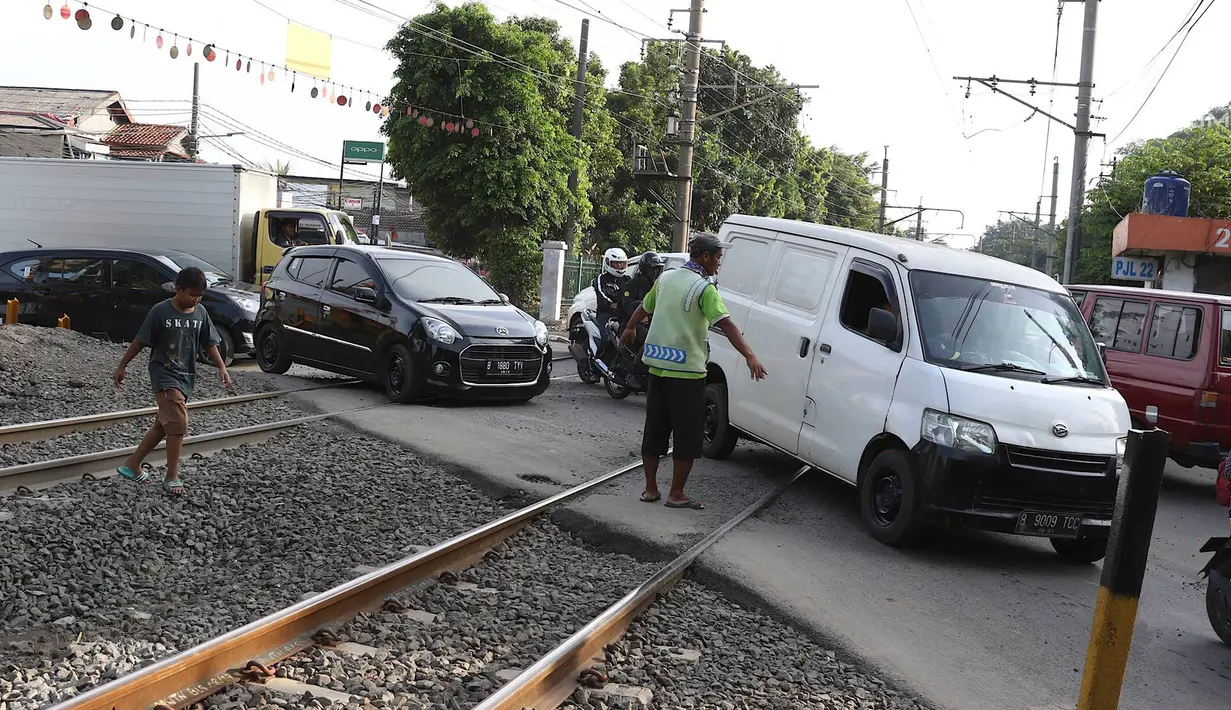 Kendaraan melintasi perlintasan kereta api di kawasan Lenteng Agung, Jakarta, Kamis (14/3). Pembangunan fly over berbentuk tapal kuda tersebut diprediksi akan mengurangi tingkat kemacetan antara 40-50 persen. (Liputan6.com/Immanuel Antonius)