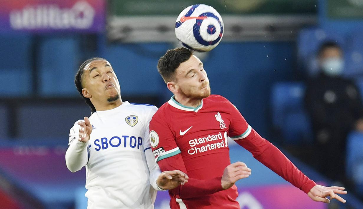 Bek Liverpool, Andrew Robertson, duel udara dengan pemain Leeds United, Helder Costa, pada laga Liga Inggris di Stadion Elland Road, Senin (19/4/2021). Kedua tim bermain imbang 1-1. (Paul Ellis/Pool via AP)