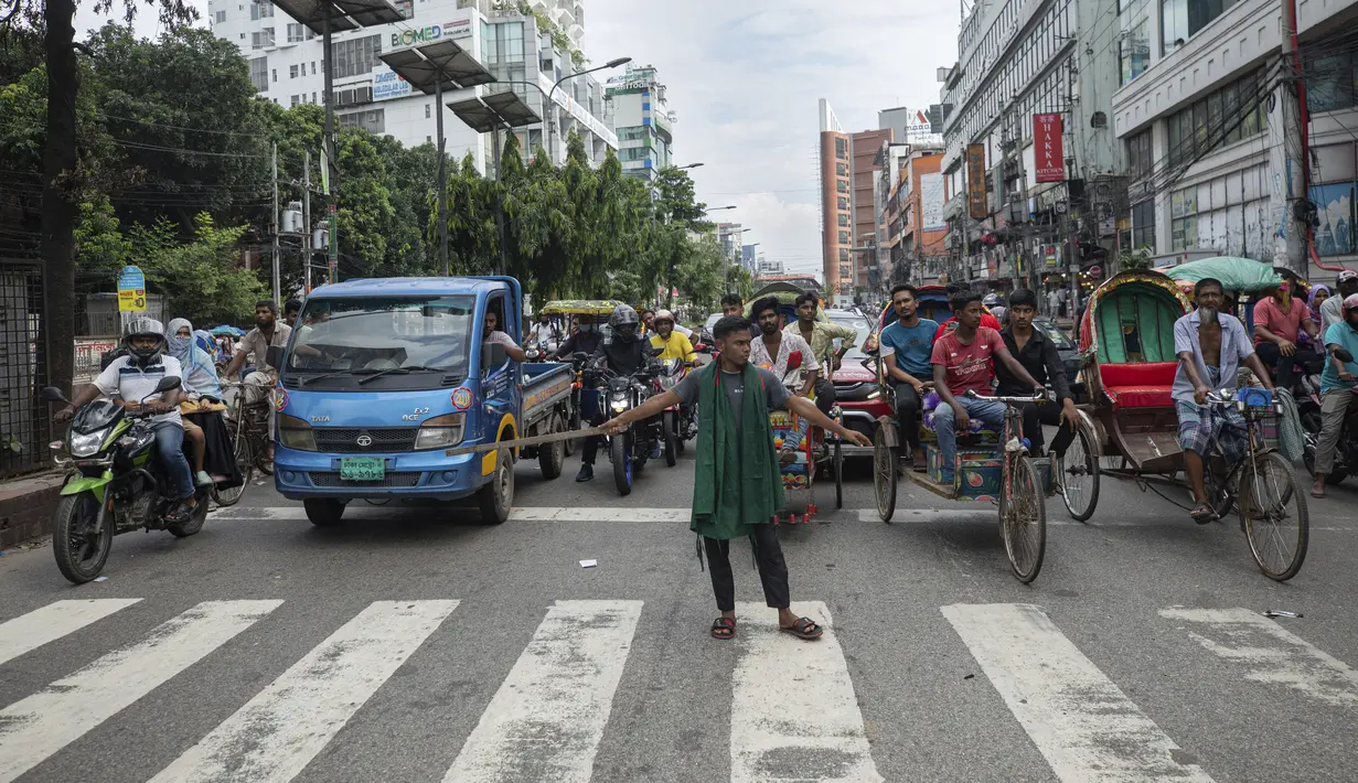 Seorang relawan mengatur lalu lintas jalan raya di Dhaka, Bangladesh, Selasa (6/8/2024). (AP Photo/Rajib Dhar)