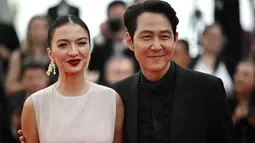 Aktris Indonesia Raline Shah (kiri) bersama aktor dan sutradara Korea Selatan Lee Jung-Jae tiba untuk pemutaran film "Decision to Leave (Heojil Kyolshim)" selama Festival Film Cannes edisi ke-75 di Cannes, Prancis selatan, pada 23 Mei 2022. Keduanya tampil serasi dengan perpaduan busana monokrom. Raline Shah dan Lee Jung Jae juga saling rangkul. (Photo by LOIC VENANCE / AFP)