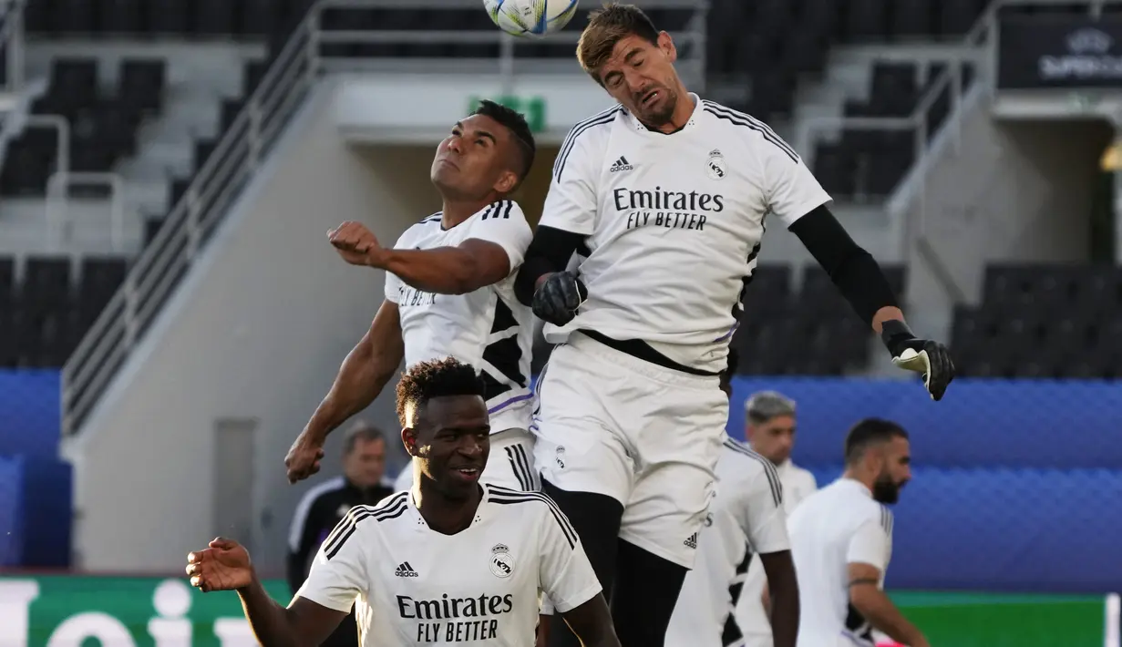 Penjaga gawang Real Madrid, Thibaut Courtois berebut bola udara dengan gelandang Casemiro saat mengikuti sesi latihan di Stadion Olimpiade Helsinki, Finlandia (9/8/2022). Real Madrid akan bertanding melawan Eintracht Frankfurt pada Piala Super Eropa 2022. (AP Photo/Sergei Grits)