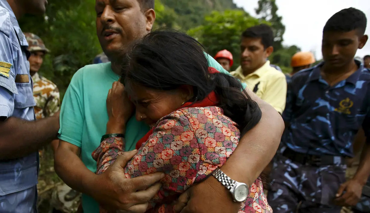 Seorang anggota keluarga menangis setelah menemukan jasad kerabatnya yang menjadi korban tanah longsor di Desa Lumle, Nepal (30/7/2015). Tanah longsor yang dipicu hujan deras tersebut menewaskan sedikitnya 30 orang. (REUTERS/Navesh Chitrakar)  