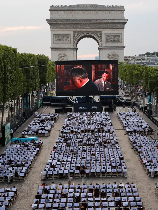 Sebuah film gratis yang diputar di ruang terbuka di jalan Champs Elysees, Paris (7/7/2019). Bioskop terbuka ini menyediakan 1800 kursi bagi penonton yang ingin menyaksikan film-film gratis yang ditayangkan. (AP Photo/Michel Euler)