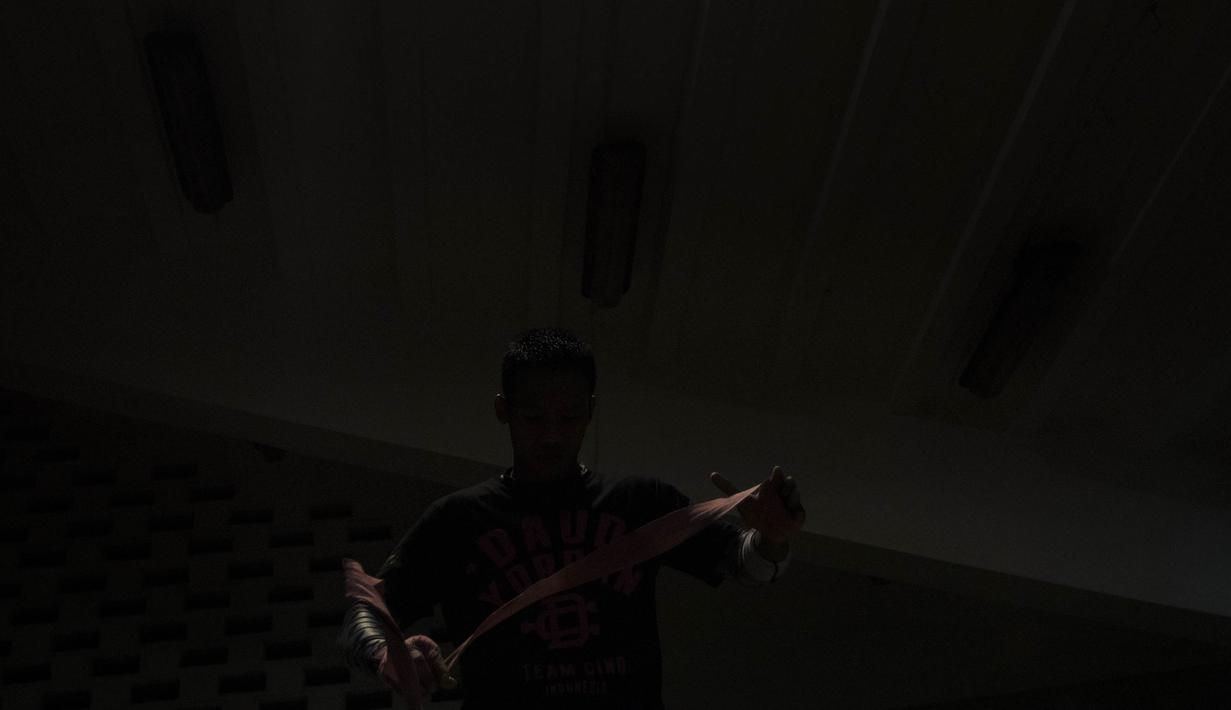 Petinju yang akrab disapa Cino sedang memasang pelindung tangan saat akan berlatih. (Bola.com/Vitalis Yogi Trisna)