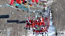 Para pemain ski berpakaian seperti Sinterklas menaiki lift ski selama berpartisipasi dalam acara tahunan Santa Sunday di Sunday River Resort yang terletak di Kota Newry, Amerika Serikat, Minggu (8/12/2019). Santa Sunday merupakan acara amal tahunan untuk River Fund Charity. (Joseph Prezioso / AFP)