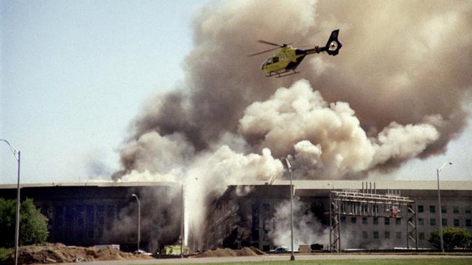 File foto sebuah helikopter terbang di atas Pentagon di Washington saat asap mengepul di atas gedung pada 11 September 2001, setelah sebuah pesawat yang dibajak menabrak sisi barat gedung, menewaskan 184 orang. (AP Photo/Heesoon Yim, File)