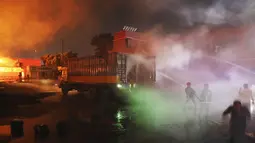 Petugas pemadam kebakaran berupaya memadamkan api yang berkobar di BM Inland Container Depot, perusahaan patungan Belanda-Bangladesh, di Chittagong, 216 kilometer (134 mil) tenggara ibu kota, Dhaka, Bangladesh, Minggu pagi (5/6/2022).Pejabat setempat melaporkan, kebakaran bermula usai ledakan besar yang memicu sejumlah ledakan kontainer di lokasi tersebut. (AP Photo)