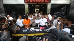Kabid Humas Polda Metro Jaya Kombes Awi Setiyono menunjukkan barang bukti serta tersangka kasus videotron porno di Prapanca, Kebayoran Baru, berinisal SAR, saat rilis kasus videotron di Polda Metro Jaya, Rabu (5/10). (Liputan6.com/Immanuel Antonius)