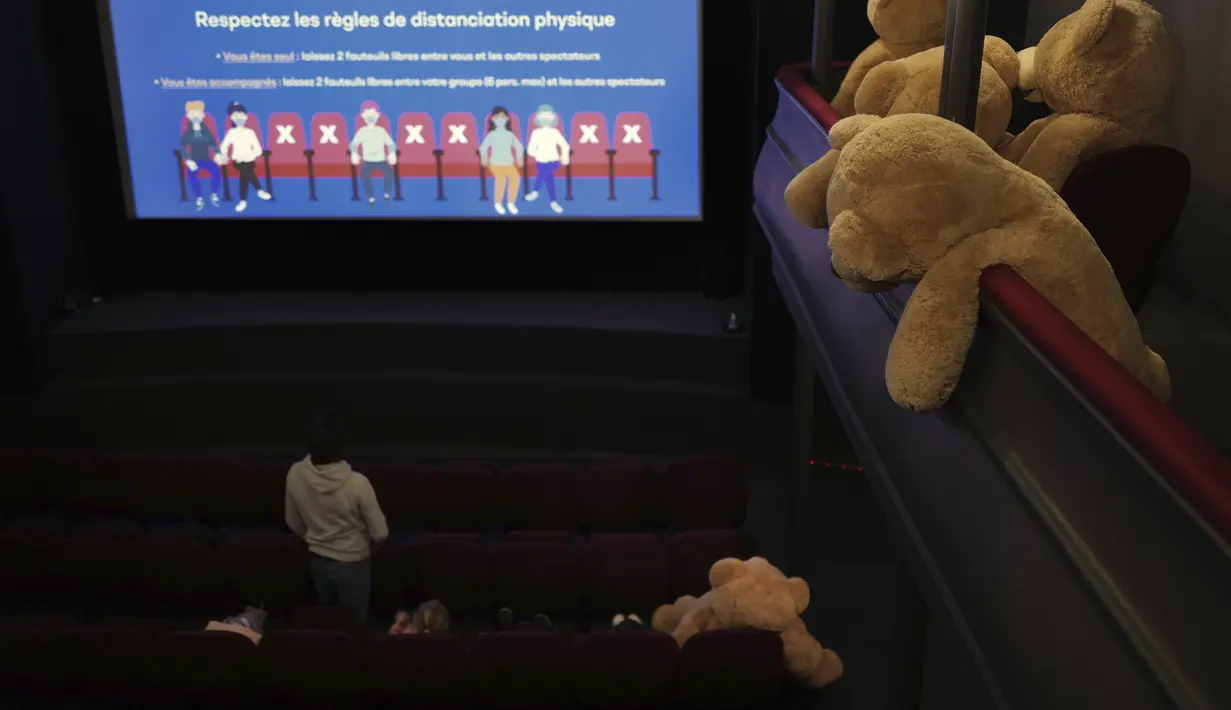 Pengunjung menonton ditemani boneka Teddy Bear, yang disiapkan oleh Philippe Labourel, di bioskop Les Ursulines hari pertama pembukaan kembali di Paris, Rabu (19/5/2021). Boneka-boneka beruang tersebut didedikasikan bagi anak-anak untuk mengingatkan aturan jarak sosial. (AP Photo/Francois Mori)