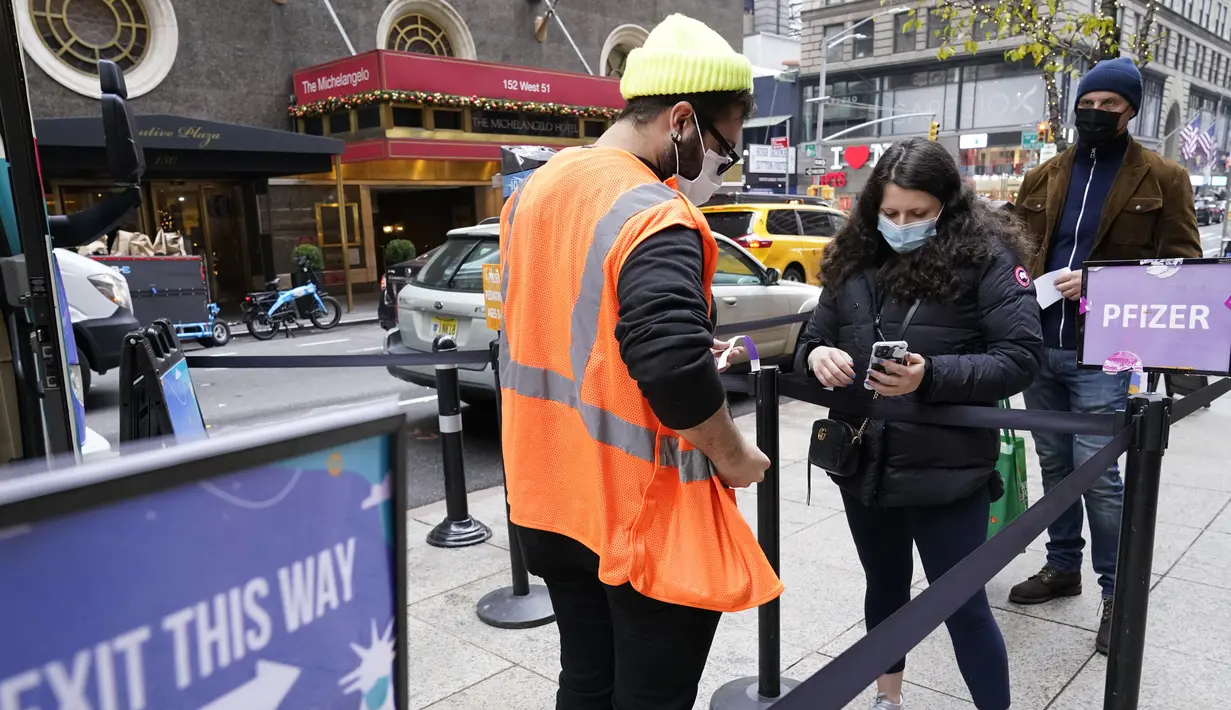 Pekerja kesehatan memeriksa orang-orang di klinik vaksin keliling NYC di Midtown Manhattan, Senin (6/12/2021). Wali Kota Bill de Blasio mengumumkan semua pengusaha swasta Kota New York harus mewajibkan pekerja mereka untuk divaksinasi COVID-19 mulai 27 Desember. (AP Photo/Mary Altaffer)