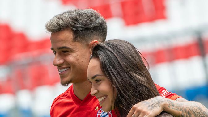 Pemain baru Bayern Munchen Philippe Coutinho (kiri) berpose bersama istrinya Aina Coutinho saat presentasi di Munich, Jerman, Senin (19/8/2019). Gelandang asal Brasil tersebut meninggalkan Barcelona dan pindah ke Bayern Munchen dengan status pinjaman. (Peter Kneffel/dpa via AP)