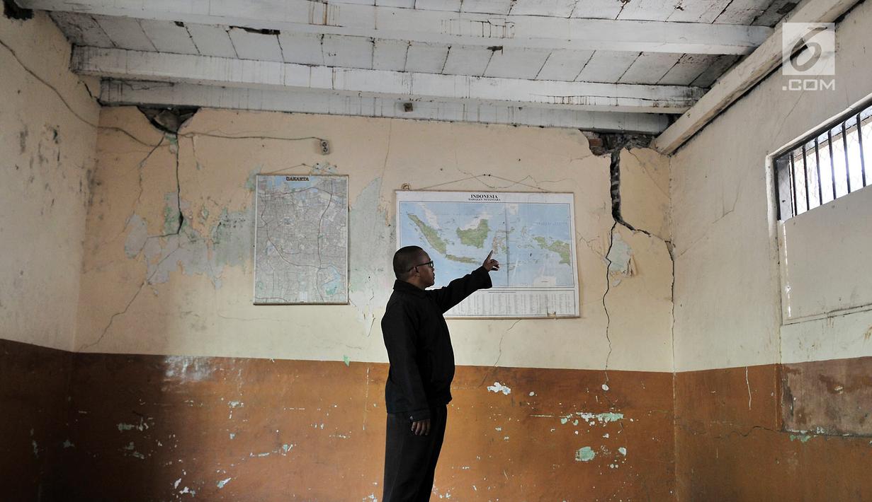 Seorang guru menunjukkan kondisi salah satu ruang kelas di SMP Negeri 32, Pejagalan, Tambora, Jakarta, Selasa (14/8). Para orangtua siswa mengeluh karena lokasi SMPN 159 yang jauh sehingga menambah biaya transportasi. (Merdeka.com/ Iqbal S. Nugroho)