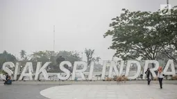 Sejumlah wanita berpose saat mengunjungi alun-alun Kabupaten Siak, Riau, Kamis (12/9/2019). Asap pekat kebakaran lahan gambut tersebut selain mengganggu kesehatan serta mencemari udara sehingga kualitasnya turun ke status tidak sehat. (Liputan6.com/Faizal Fanani)
