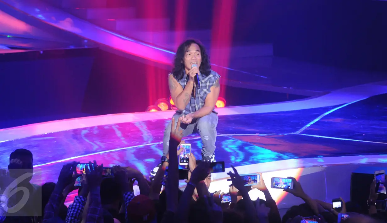 Penonton mengambil gambar Kaka saat tampil di Konser Raya 22 Indosiar, Jakarta, Rabu (11/1). Kehadiran Slank semakin membuat panggung Konser Raya 22 Indosiar semakin bergairah. (Liputan6.com/Helmi Afandi)
