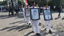 Mahasiswa berjalan sambil memegang foto aktivis yang tewas saat menggelar aksi peringatan 'Tragedi Trisakti 12 Mei 1998' di Universitas Trisakti, Jakarta, Selasa (12/5/2015). (Liputan6.com/Johan Tallo)
