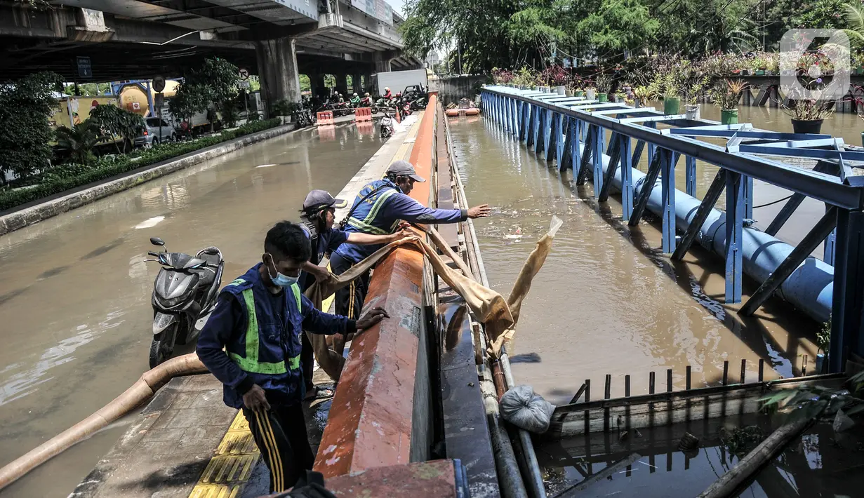 Petugas menggunakan pompa saat menyedot banjir yang menggenangi Jalan RE Martadinata, Ancol, Jakarta, Selasa (9/11/2021). Banjir mengakibatkan akses dari arah Jalan Gunung Sahari menuju Penjaringan ditutup sementara dan pengendara disarankan mencari jalan alternatif. (merdeka.com/Iqbal S. Nugroho)