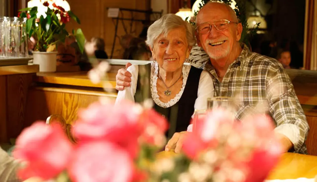 Seorang pelayan asal Jerman, Kathi Kink duduk bersama seorang tamu di restoran 'Zum Goldenen Tal' di Weyarn, Jerman. Foto diambil pada 1 Februari 2015. (REUTERS/Michaela Rehle)