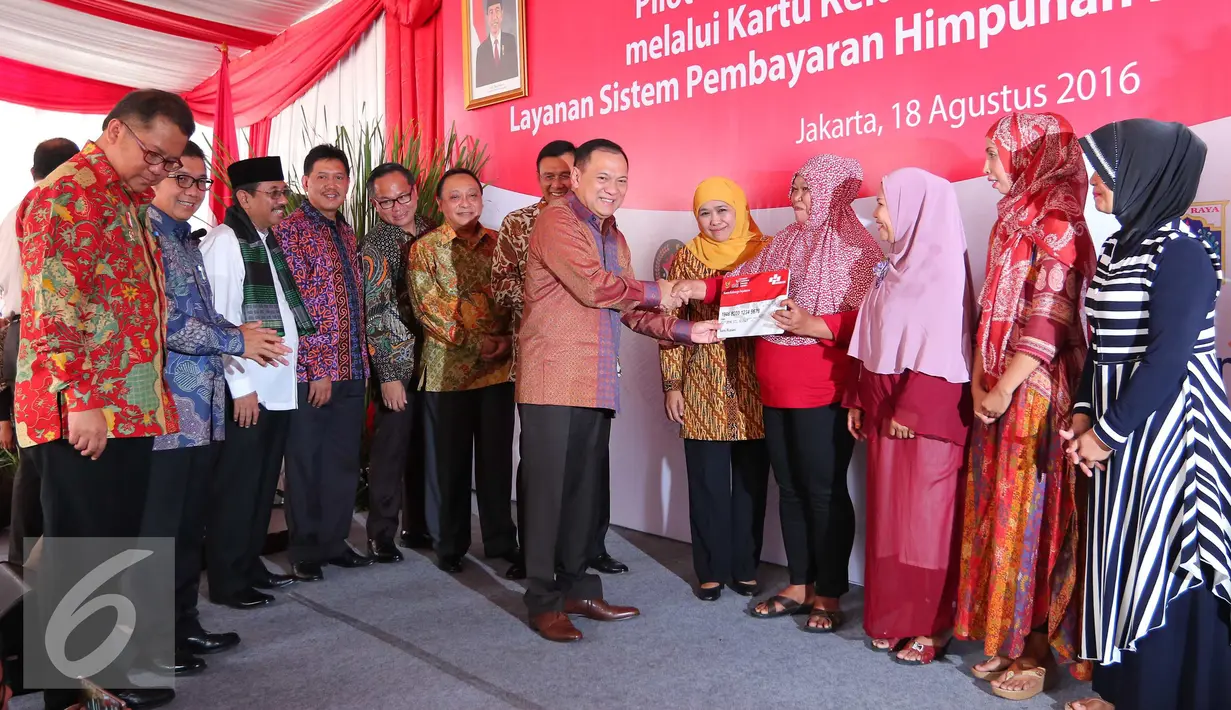 Gubernur BI Agus Martowardojo berjabat tangan dengan warga saat peresmian pilot project penyaluran bantuan sosial melalui Kartu Keluarga Sejahtera (KKS), Jakarta, Kamis (18/08). (Liputan6.com/Angga Yuniar)