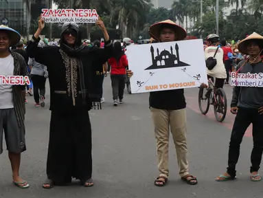 Aktivis dari Dompet Dhuafa melakukan sosialisasi saat Hari Bebas Kendaraan Bermotor (HBKB) di kawasan M.H Thamrin, Jakarta, (29/5/2016). Sosialisasi tersebut dilakukan untuk mengajak masyarakat akan pentingnya berzakat.(Liputan6.com/ Herman Zakharia)