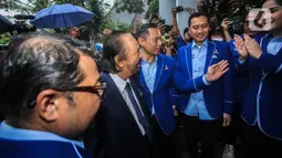 Ketua Umum Partai Demokrat Agus Harimurti Yudhoyono (AHY) menerima kunjungan Ketua Umum Partai NasDem Surya Paloh di DPP Partai Demokrat, Jakarta, Rabu (22/2/2023). Hujan rintik-rintik mengiringi kedatangan Surya Paloh sementara AHY langsung memayunginya. (Liputan6.com/Faizal Fanani)