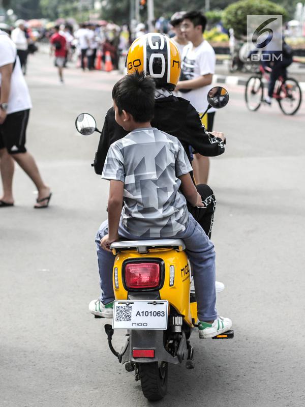 Pengendara sepeda motor listrik Migo saat melintasi CFD di kawasan Bundaran HI, Jakarta, Minggu (17/2). Petugas Dishub menghimbau penyewa untuk tidak melintasi jalan raya karena belum memenuhi uji layak operasi. (Liputan6.com/Faizal Fanani)