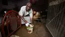 Seorang pria Sudan mengeluarkan air dari rumahnya di daerah banjir alqamayir di kota kembar ibu kota Omdurman (26/8/2020). (AFP Photo/Ashraf Shazly)