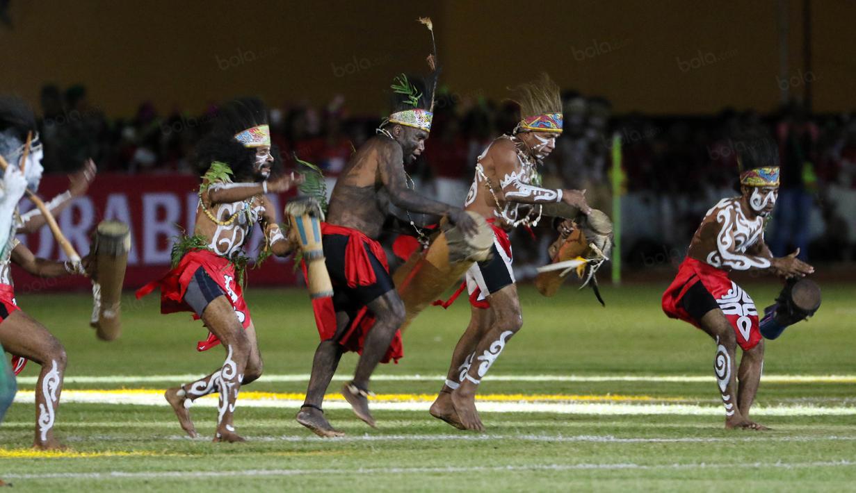 Penari beraksi dengan tifa saat acara pembukaan Torabika Soccer Championship 2016 di Stadion Mandala, Jayapura, Papua, Jumat (29/4/2016). (Bola.com/Nicklas Hanoatubun)