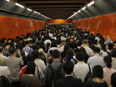 Penumpang mengantri di platform kereta bawah tanah di Hong Kong (30/7/2019). Para pengunjuk rasa telah mengganggu layanan kereta bawah tanah pada pagi hari perjalanan dengan menghalangi pintu-pintu masuk kereta dan mencegah mereka meninggalkan stasiun. (AP Photo/Vincent Yu)