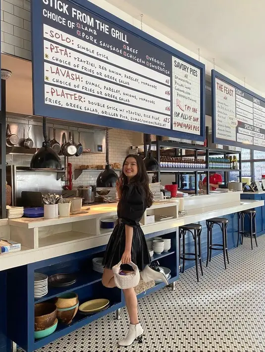 Tampil serba monokrom, Raline Shah memadukan kemeja dengan mini skirt warna hitam. Artis yang kini menetap di luar negeri ini juga mengenakan hand bag dan sepatu boots warna putih. (Instagram/ralineshah).