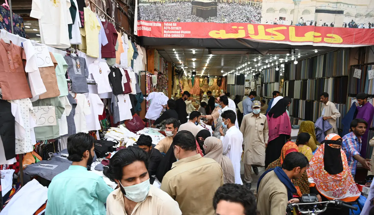 Orang-orang membeli pakaian saat berbelanja menjelang festival Idul Fitri yang akan datang di tengah pandemi corona Covid-19, di Rawalpindi, Pakistan pada 5 Mei 2021. Pusat perbelanjaan ramai oleh warga Pakistan yang berbelanja aneka kebutuhan untuk menyambut Lebaran. (Farooq NAEEM / AFP)