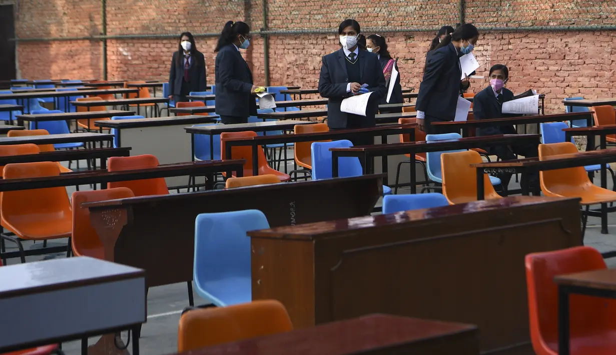 Siswa yang mengenakan masker tiba untuk ujian kenaikan kelas XII di lapangan sekolah di Kathmandu, Nepal, Senin (23/11/2020). Nasib sekitar 450.000 siswa kelas XII digantung akibat COVID-19 saat ujian yang dijadwalkan mulai 20 April ditunda karena lockdown pada 24 Maret lalu. (PRAKASH MATHEMA/AFP)