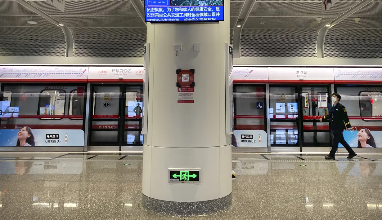 Seorang pekerja stasiun yang mengenakan masker berjalan melalui stasiun kereta bawah tanah kosong di sebelah resor Universal Studios Beijing, yang menurut pemberitahuan ditutup untuk pengendalian epidemi, di Beijing, Rabu  (26/10/2022). Kota Shanghai di China mulai memberikan vaksin COVID-19 yang dapat dihirup pada hari Rabu di tempat yang tampaknya menjadi yang pertama di dunia. (AP/Mark Schiefelbein)