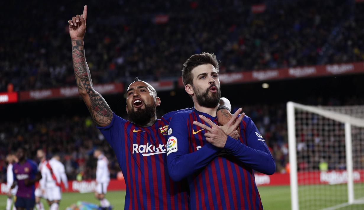 Bek Barcelona, Gerard Pique dan Arturo Vidal melakukan selebrasi usai membobol gawang Rayo Vallecano pada laga La Liga di Stadion Camp Nou, Sabtu (9/3). Barcelona menang 3-1 atas Rayo Vallecano. (AP/Manu Fernandez)