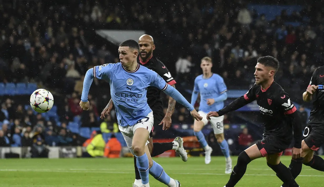 Gelandang Manchester City, Phil Foden berlari dengan bola di depan pemain Sevilla Jose Angel Carmona selama pertandingan pertandingan lanjutan Grup G Liga Champions di stadion Etihad di Manchester, Inggris, Kamis (3/11/2022). Man City menang atas Sevilla dengan skor 3-1. (AP Photo/Rui Vieira)
