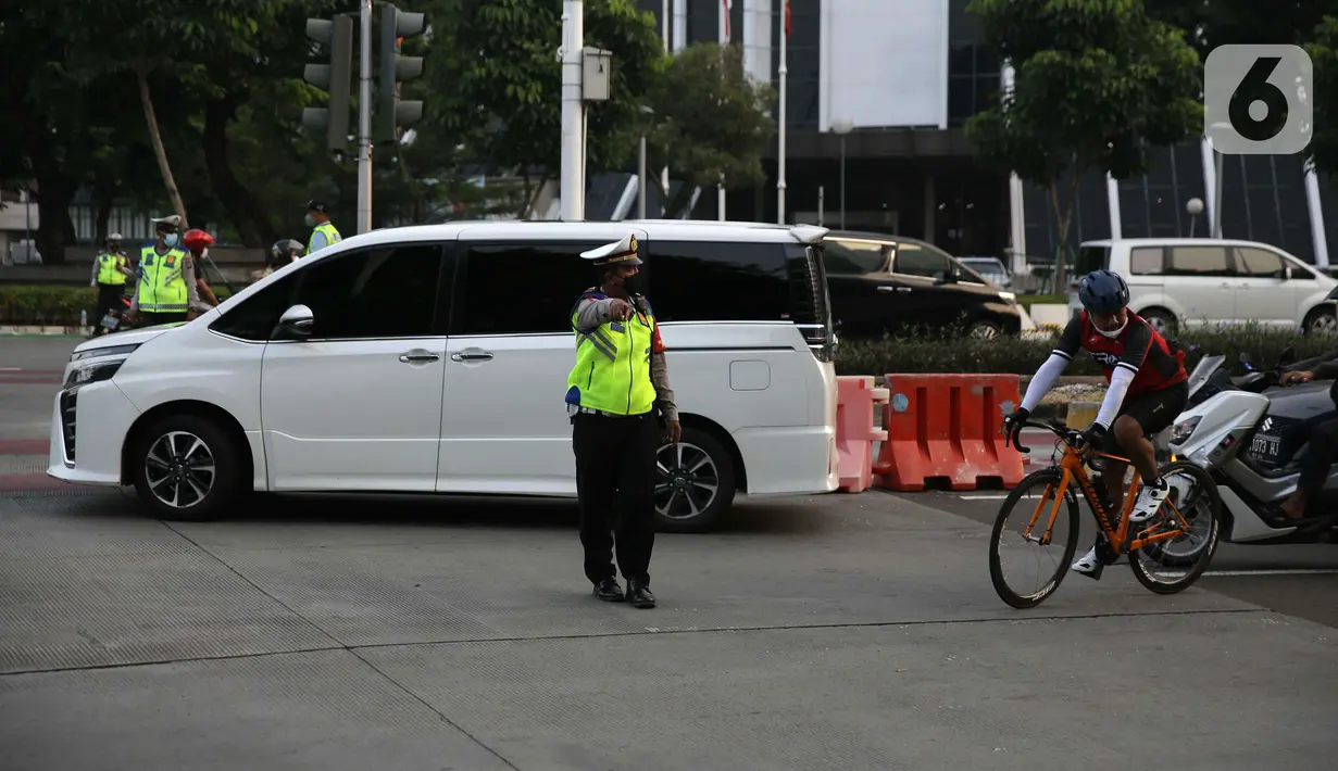 Polisi menghalau pesepeda yang berada di luar jalur di kawasan Sudirman-Thamrin, Jakarta Pusat, Rabu (2/6/2021). Wakil Gubernur DKI Jakarta Ahmad Riza Patria mengatakan, sepeda road bike diperbolehkan untuk melintas di Jalan Sudirman-Thamrin pada hari kerja Senin-Jumat. (Liputan6.com/Faizal Fanani)